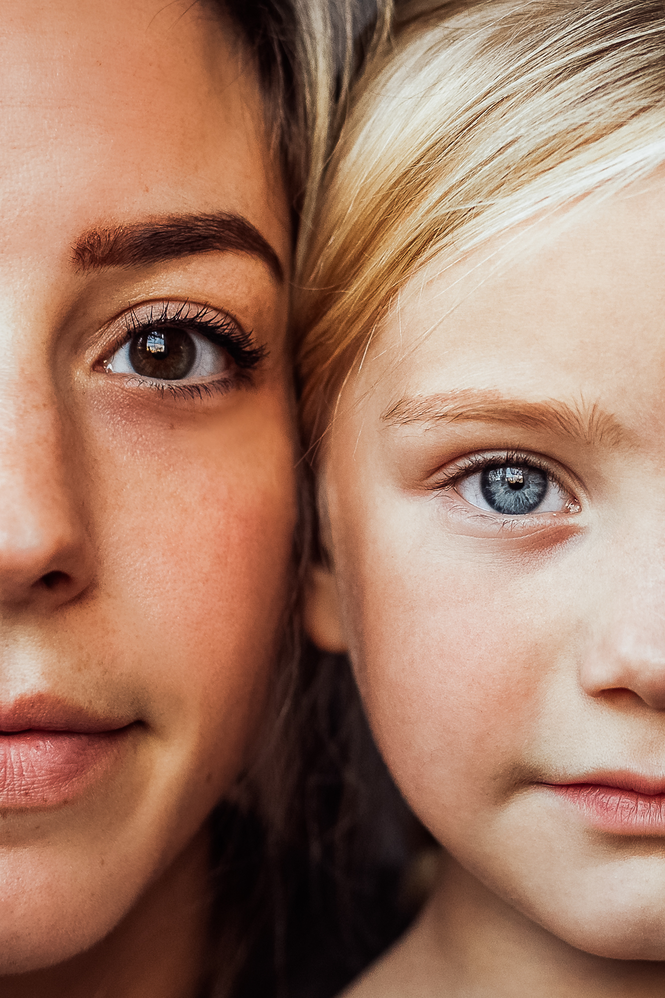 half of a mother and daughters faces up close side by side 