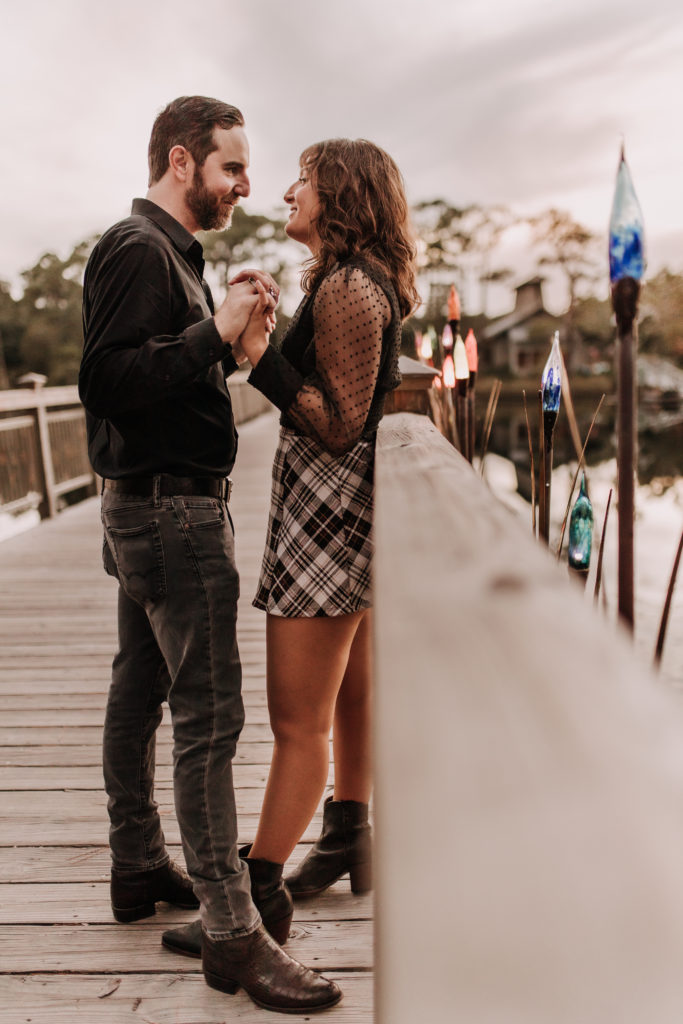 couple looking into each other's eyes, while holding hands on the bridge in Watercolor, Florida