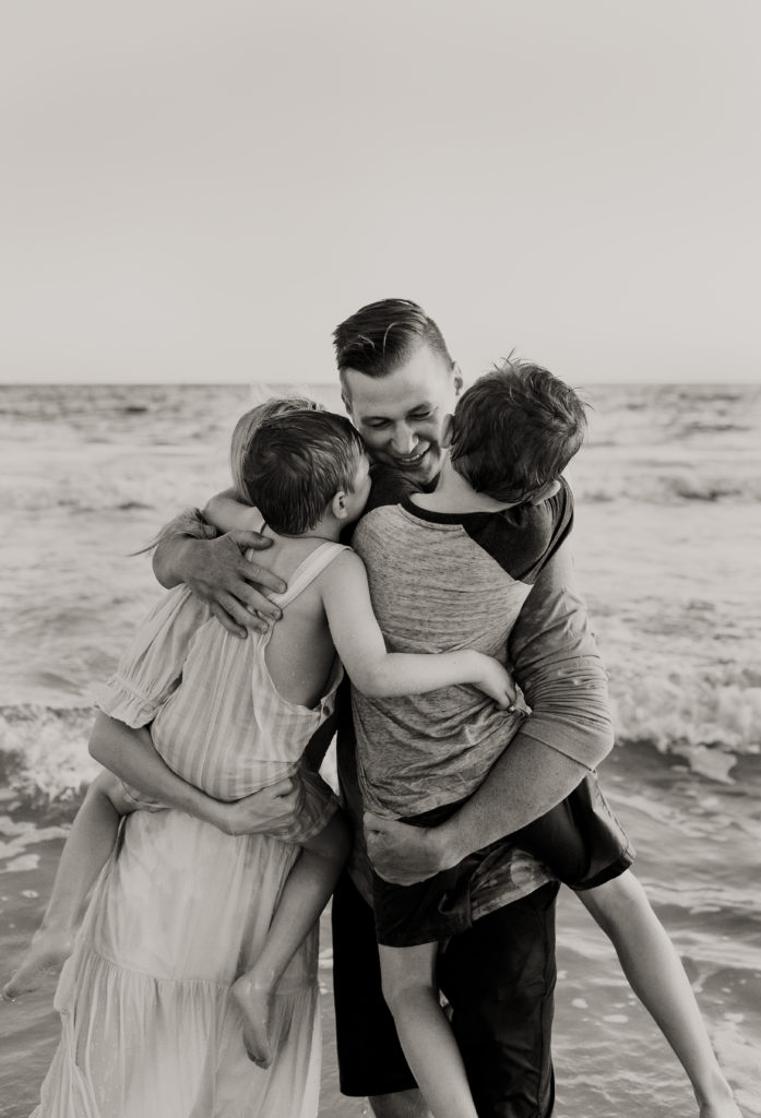 family embracing at the beach